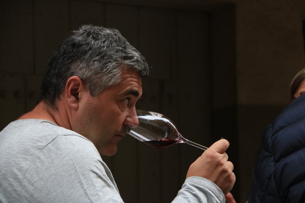 Un home olora una copa de vi de la DO Terra Alta abans de tastar-lo, a la mostra de vins de Batea  